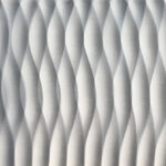 A white tile with wavy lines on it.