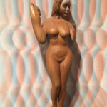 A wooden sculpture of a naked woman.